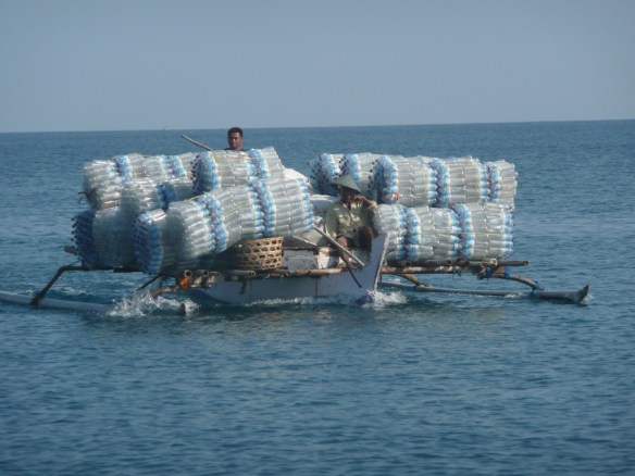 Medana bay – Lombok. Pirogue de pêche reconvertie en transport de bouteilles d’eau pour les touristes des Gili.