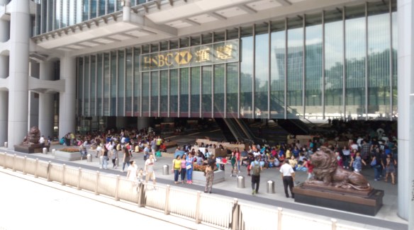 Hong Kong – Dimanche après-midi sur le parvis, ombragé, du siège de HSBC, les bonnes Philippines se retrouvent pour festoyer et soigner le mal du pays.