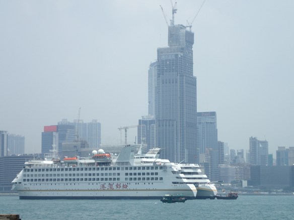 Hong Kong – Causeway bay. Ce trou à typhon naturel coincé entre Kowloon et l’ile de Hong Kong est considéré comme le centre de la ville. Bordé de gratte ciels, il concentre les plus grands centres commerciaux et les loyers parmi les plus élevés du monde.  Sous le port, tunnels routiers et ferroviaires, un entrelacs multidimensionnel de commodités qui irrigue l’île.